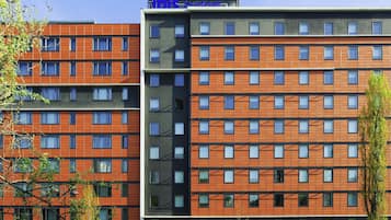 Een meerlaags hotel met een modern ontwerp, met een raster van ramen en een plat dak.