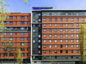 Een meerlaags hotel met een modern ontwerp, met een raster van ramen en een plat dak.