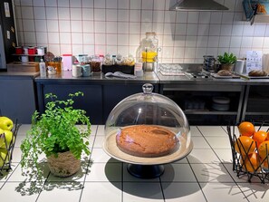 A kitchen counter with a bread display, a potted plant, and a fruit basket. - greet Hotel Paris porte de la Chapelle - Aréna (Paris)