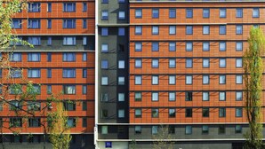 Un hôtel à plusieurs étages, doté d’un design moderne, caractérisé par une façade à motifs géométriques de fenêtres et un toit plat.