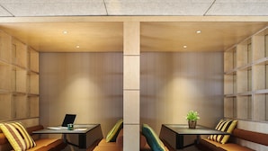 A modern interior with two seating areas, each with a table and a laptop, and a small plant on one table. - greet Hotel Paris porte de la Chapelle - Aréna (Paris)