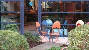 Un espace patio aménagé avec des sièges d’extérieur et des plantes en pot.