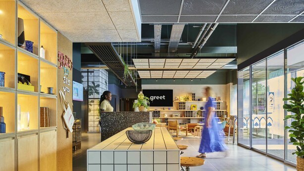 Un hall d’hôtel moderne comprenant un comptoir d’accueil, un espace salon et une grande fenêtre donnant sur l’extérieur.