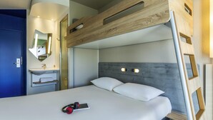 Un lit superposé avec une tête de lit en bois, une table de chevet et un miroir.