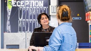 Un comptoir d’accueil avec une pancarte indiquant « RÉCEPTION » et « BUREAU ».