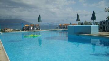 Relax by the pool surrounded by lounge chairs and umbrellas, with breathtaking views of the surrounding mountains.