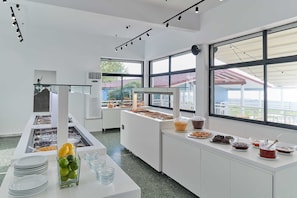 A buffet setup with various food items and a glass container with lemons.