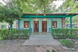 A building with a green roof and stone walls, featuring two doors and two windows. - Olympios Zeus (Dio-Olympos)