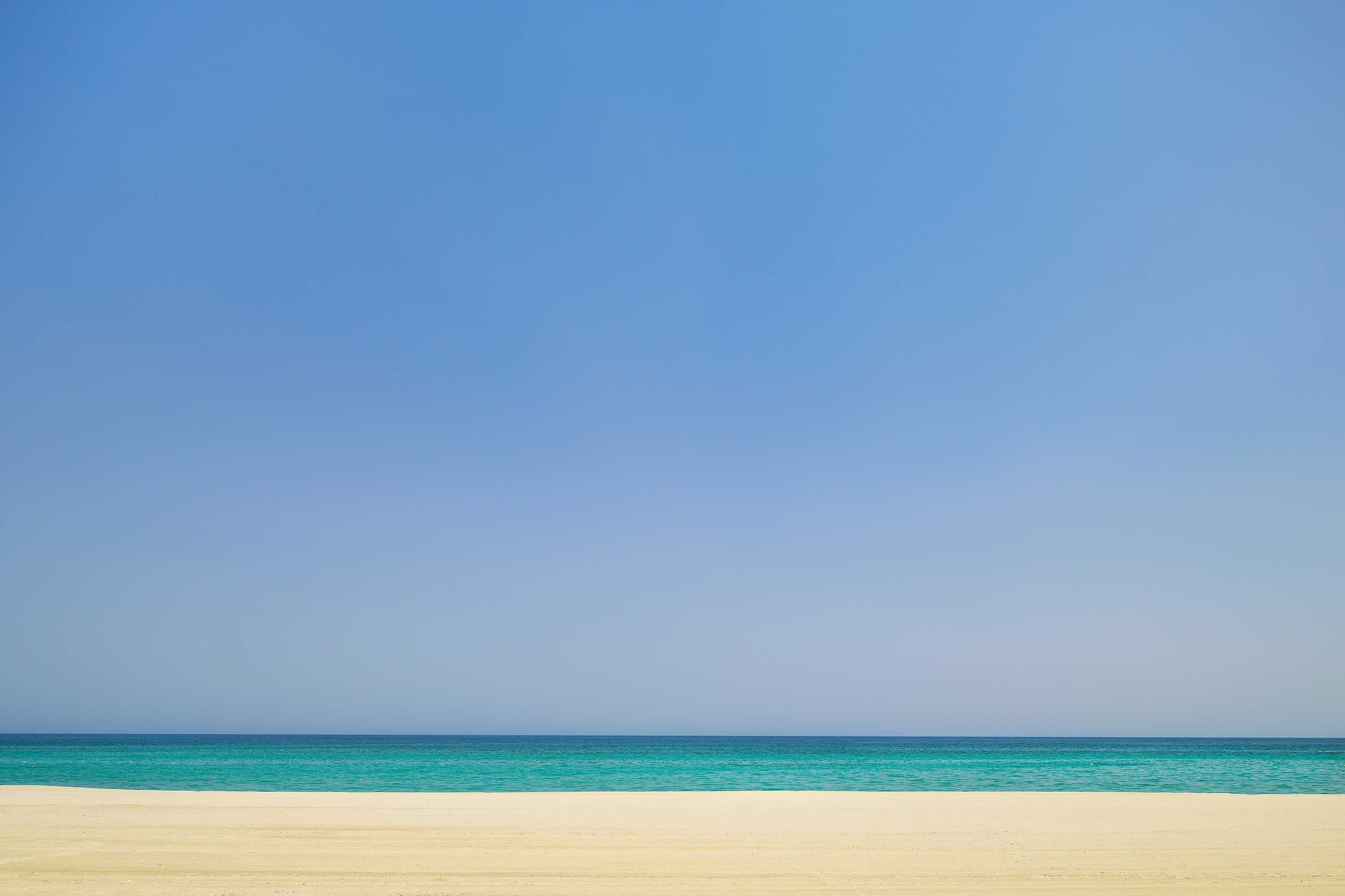 A beach with a clear sky and calm sea.