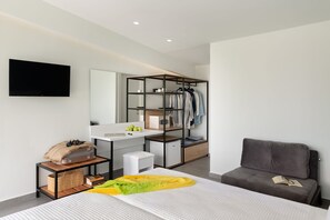 A modern bedroom with a bed, bedside table, a desk with a chair, a wardrobe, and a TV mounted on the wall. - Olympios Zeus (Dio-Olympos)