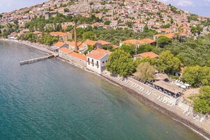 Une ville côtière avec des maisons à étages, une jetée et une plage équipée de transats.