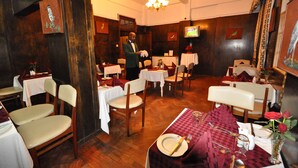 Un restaurante con paredes de madera, un candelabro y mesas dispuestas para comer.