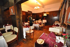 Ein Restaurant mit Holzwänden, einem Chandelier und gedeckten Tischen.