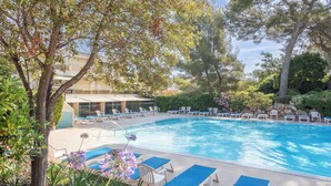 Una piscina amb gandules i un edifici al fons.
