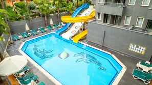 A swimming pool with slides, lounge chairs, and palm trees. - Senza Grand Santana Hotel (Alanya)