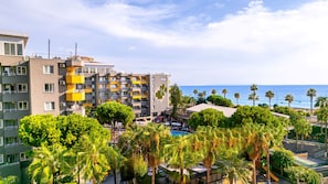 A hotel with multiple floors, balconies, and a pool area with palm trees. - Senza Grand Santana Hotel (Alanya)