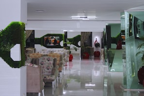 A modern interior with a glass partition, a flat-screen TV, and a reception desk. - Senza Grand Santana Hotel (Alanya)