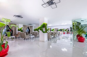 Un hall d’entrée spacieux, doté de meubles modernes, de plantes vertes et d’un sol ciré.