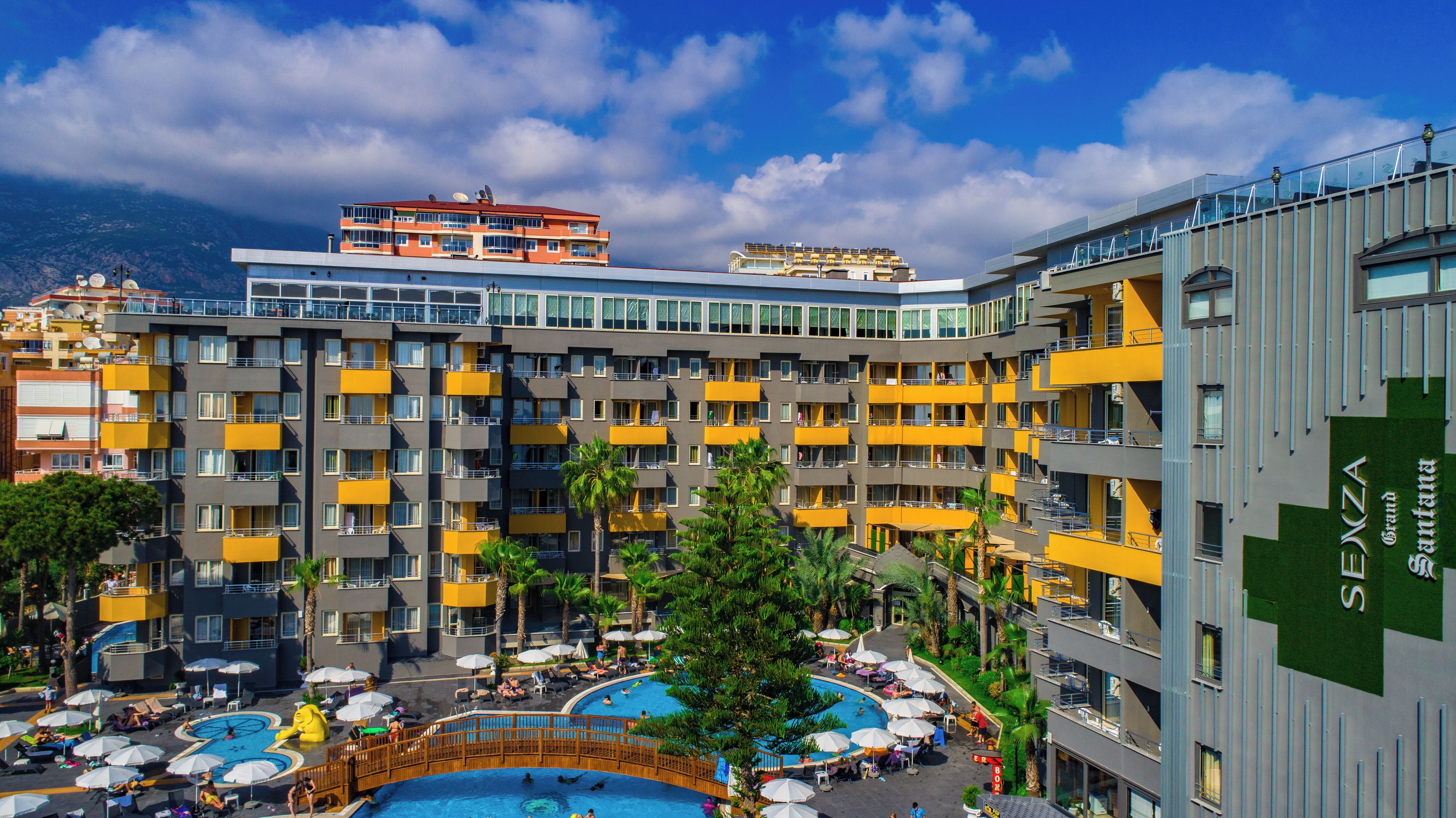 Un hôtel doté de nombreux balcons, d’une piscine et offrant une vue sur un paysage montagneux.