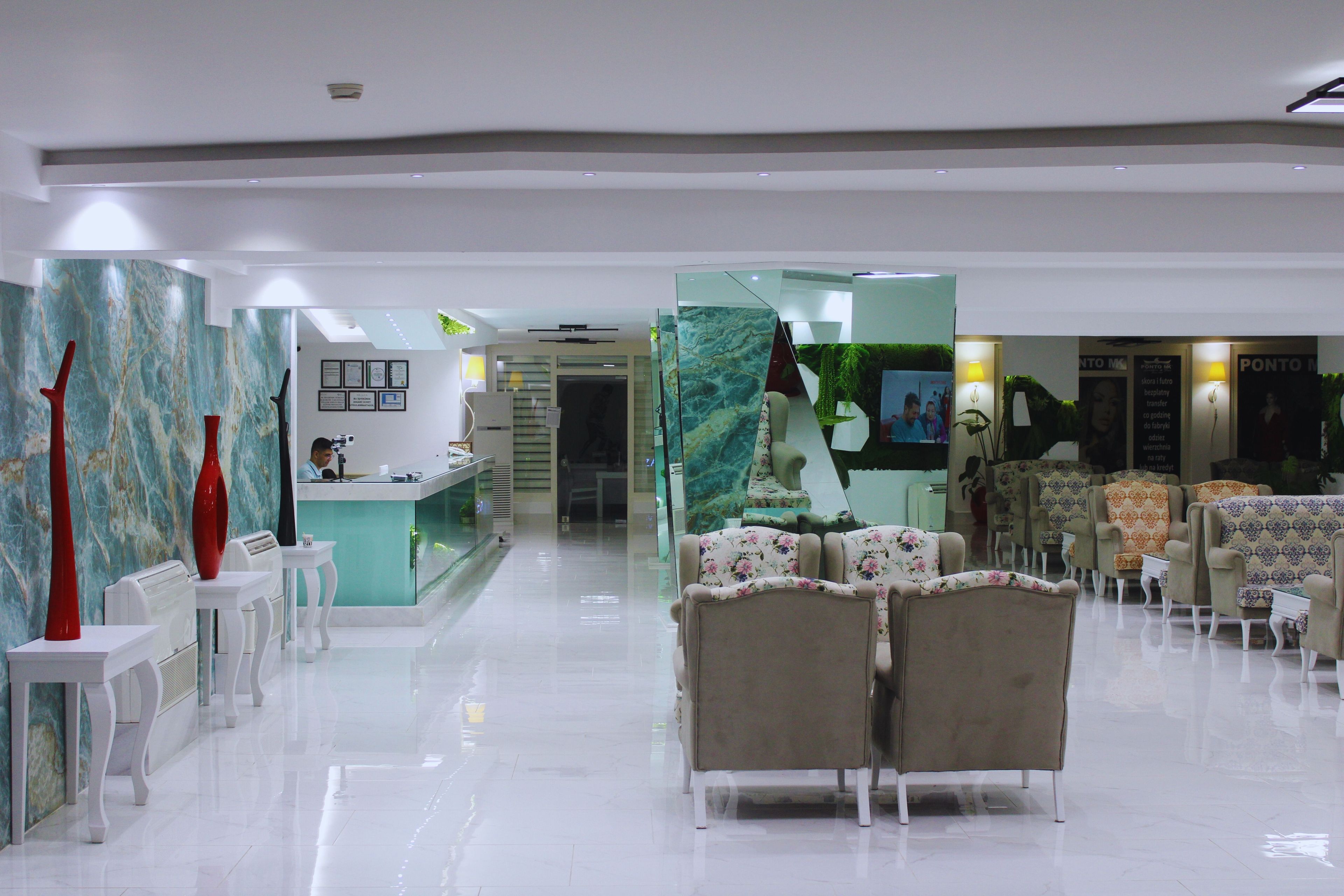 En hotellobby med en receptionsdisk, en sittgrupp och dekorativa element.