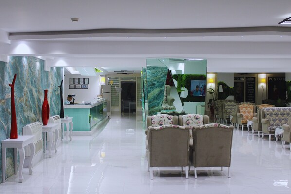A hotel lobby with a reception desk, seating area, and decorative elements. - Senza Grand Santana Hotel (Alanya)