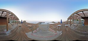 A beachside restaurant with outdoor seating and a view of the ocean. - Senza Grand Santana Hotel (Alanya)