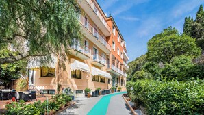 A multi-story hotel with outdoor seating and a pathway.