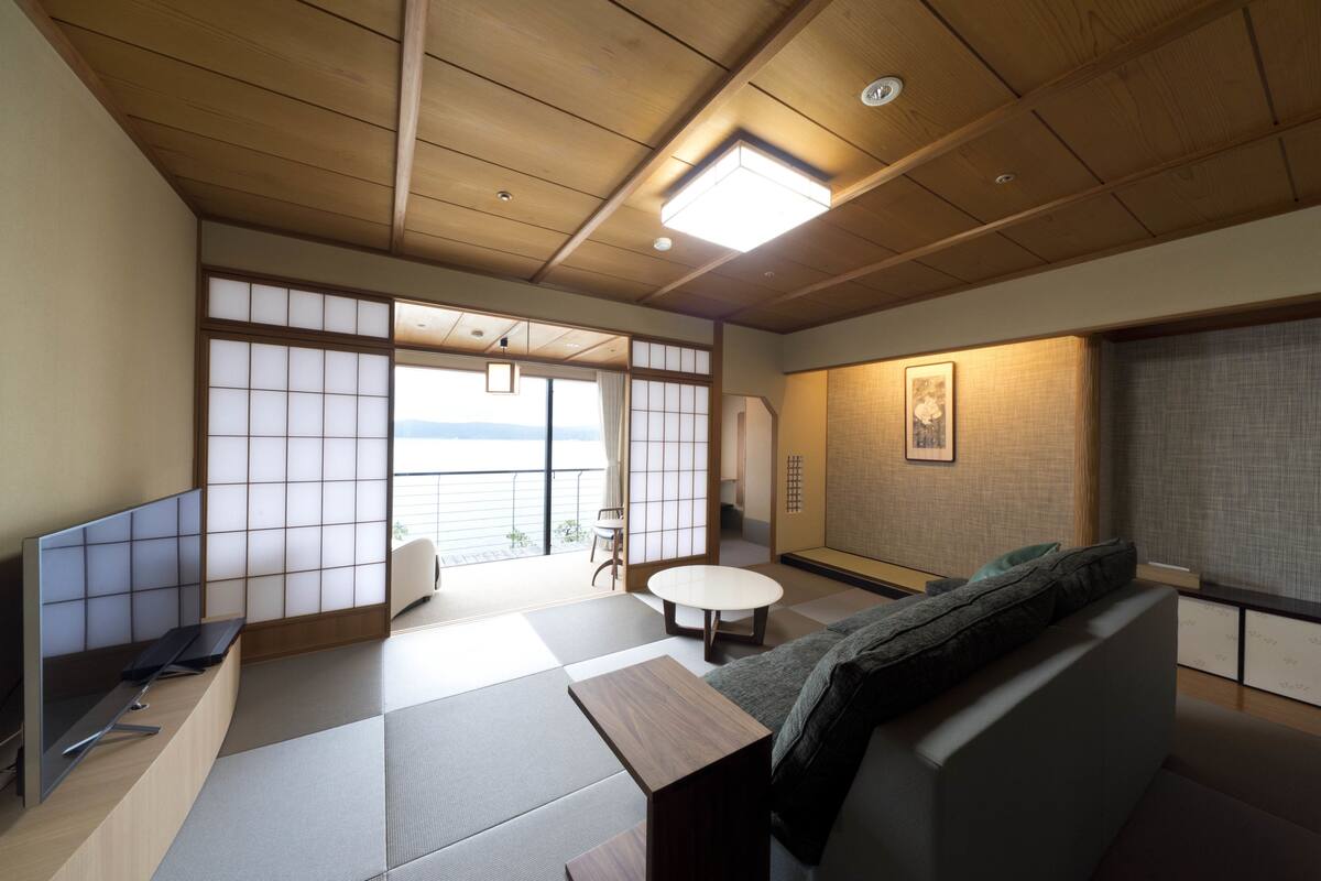 Une pièce de style japonais traditionnel, avec un sol recouvert de tatamis, un plafond bas en bois et des portes coulissantes en papier de riz (shoji).