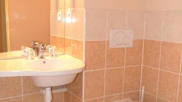 A bathroom with a sink, mirror, and toilet.