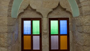 A stone archway with two windows, each divided into four panes.