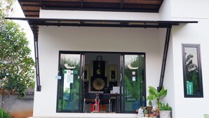 A modern building with a large glass door, a clock, and a sign indicating Wi-Fi availability. - Buabaan Villa (Krabi)