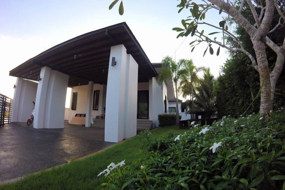 A modern building with a covered patio and a well-maintained garden.