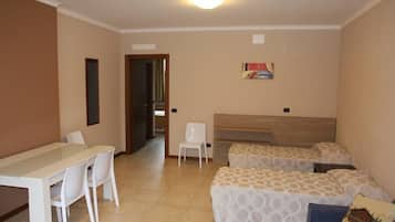 A hotel room with a bed, a desk, and chairs.