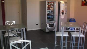 Ein Essbereich mit einem Automaten, einem Tisch und Stühlen.