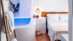 Una stanza spa con una vasca, due letti, un poggiatesta in legno e un lampadario.