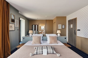 A hotel room with a large bed, bedside tables, a mirror, and a bathroom visible through an open door. - Hôtel de la Mer (Plounéour-Brignogan-Plages)