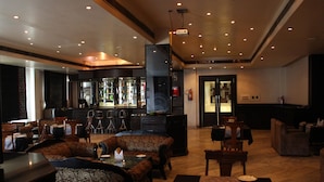 Un restaurante con zona de bar, asientos con diseño y una chimenea.