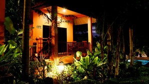 Una casa con balcón, rodeada de vegetación tropical.