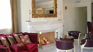 Un salon luxueux avec une cheminée, des meubles élégants et un grand miroir décoratif.