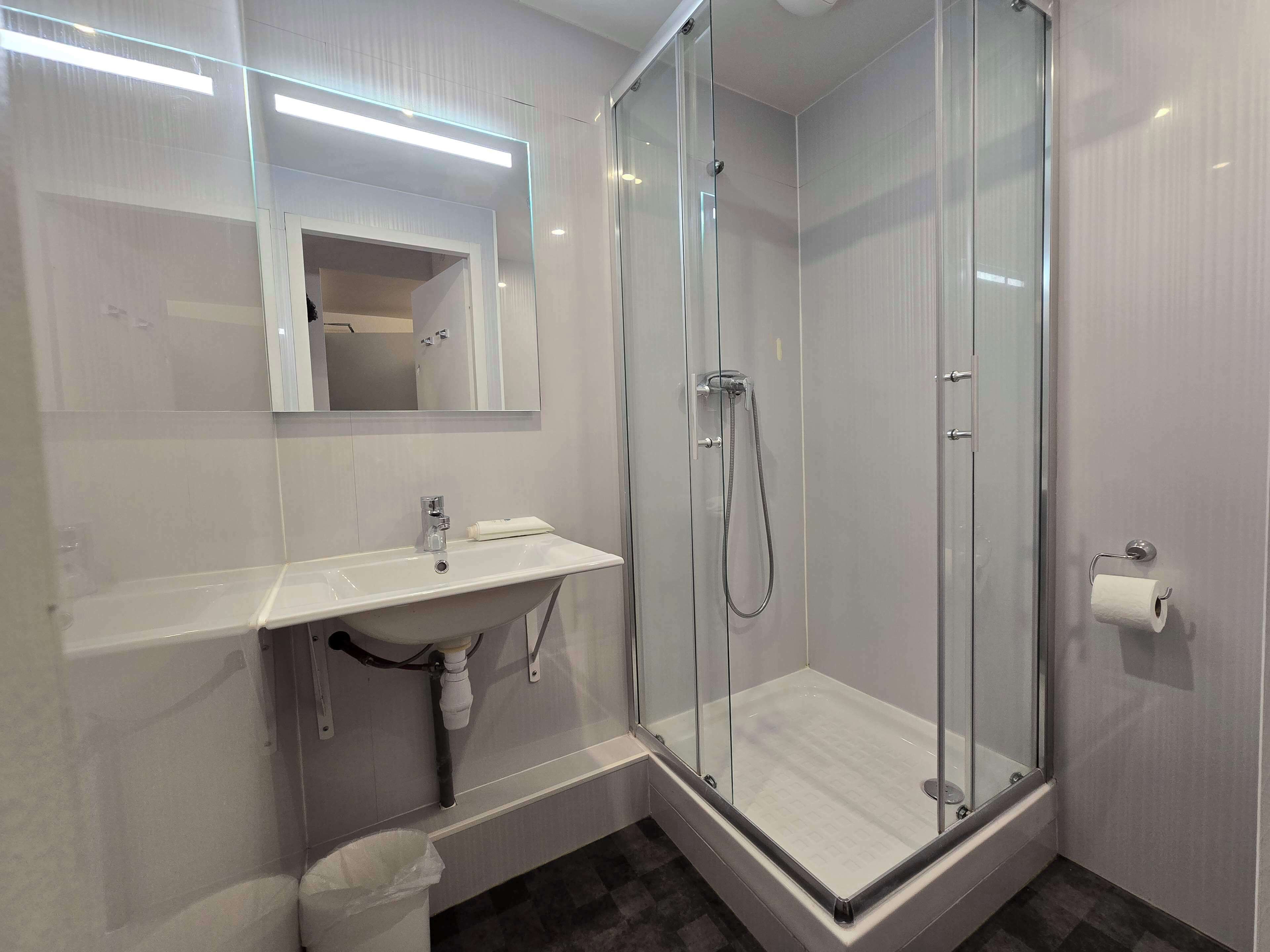 Een douche, milieuvriendelijke toiletartikelen, handdoeken