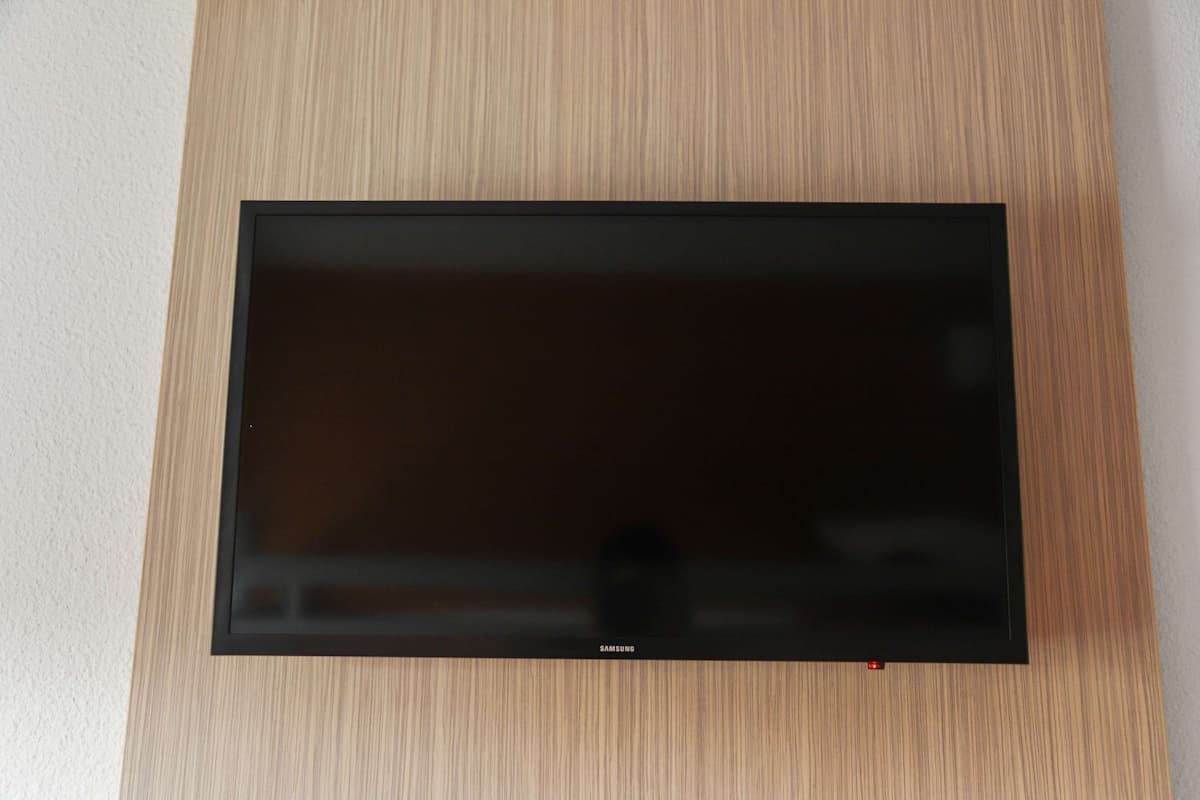 A flat-screen TV mounted on a wooden wall.