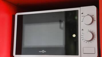 A microwave with a digital display and two control knobs.