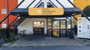 A hotel entrance with a sign reading "HOTEL PREMIERE CLASSE".