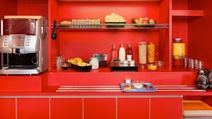 A red-themed breakfast bar with a coffee machine, bread, pastries, and various breakfast items. - hotelF1 Lyon Gerland Vénissieux (Venissieux)