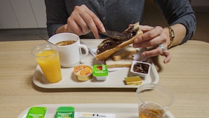 A breakfast tray with a cup of coffee, a chocolate spread on toast, a glass of orange juice, and a bowl of cereal. - hotelF1 Lyon Gerland Vénissieux (Venissieux)