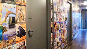 A hallway with travel posters on the walls and a door with a keypad lock. - hotelF1 Lyon Gerland Vénissieux (Venissieux)