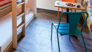 A compact room with a bunk bed, a small table with a chair, and a wall with posters. - hotelF1 Lyon Gerland Vénissieux (Venissieux)