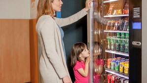 A woman and a child standing in front of a vending machine with various snacks and drinks. - hotelF1 Lyon Gerland Vénissieux (Venissieux)