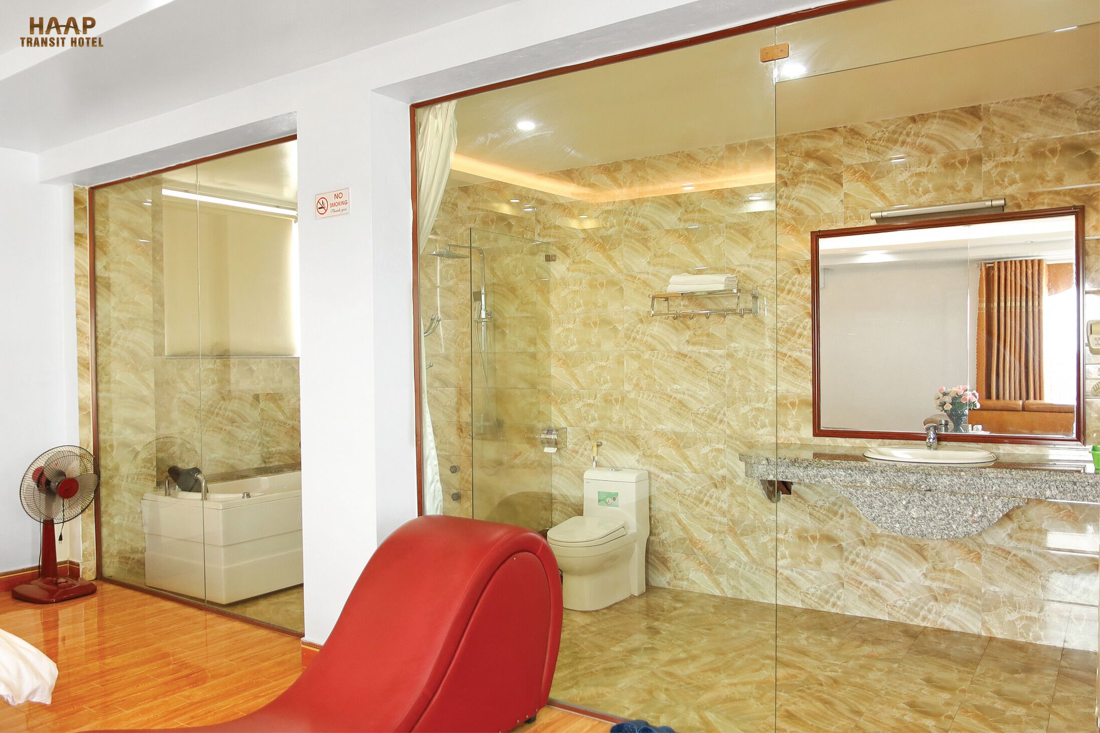 Een moderne badkamer met een douchecabine van glas, een toilet en een wastafel met een marmeren blad.