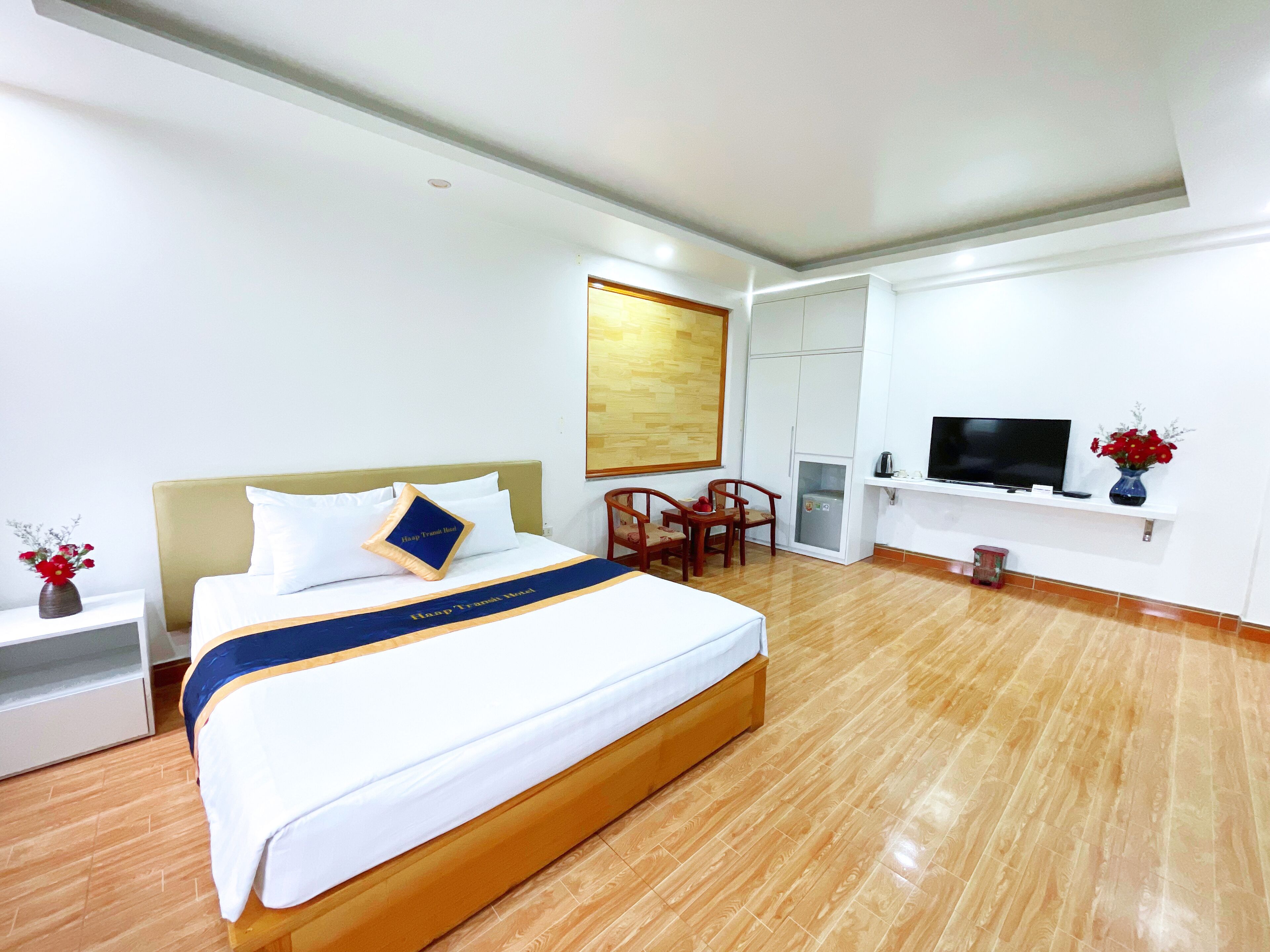 Una habitación de hotel con una cama grande, televisor, escritorio y armario.